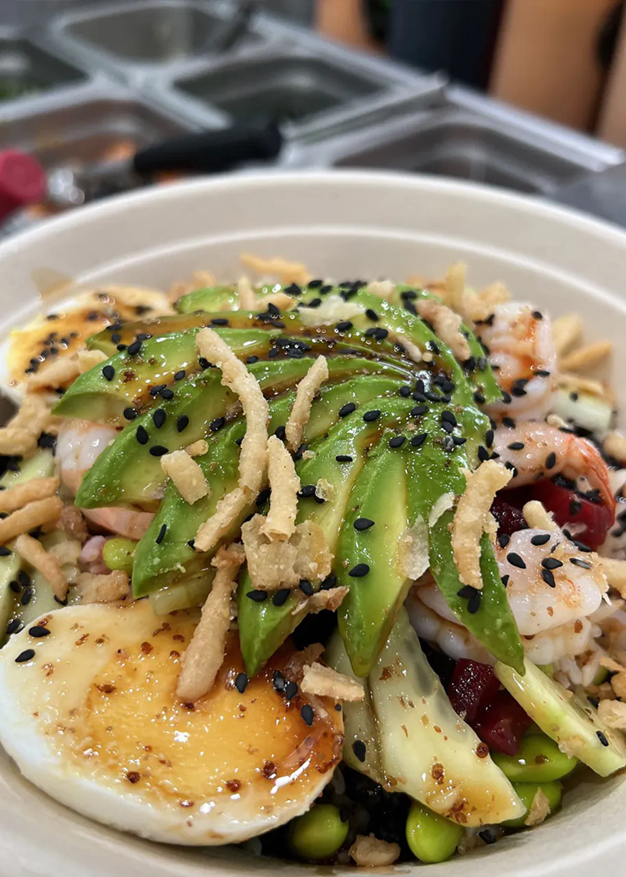 Poke bowl with avocado slices, shrimp, soft-boiled egg, edamame, and crispy toppings at Natural Kitchen Wilton, a Fast Casual Restaurant in Wilton